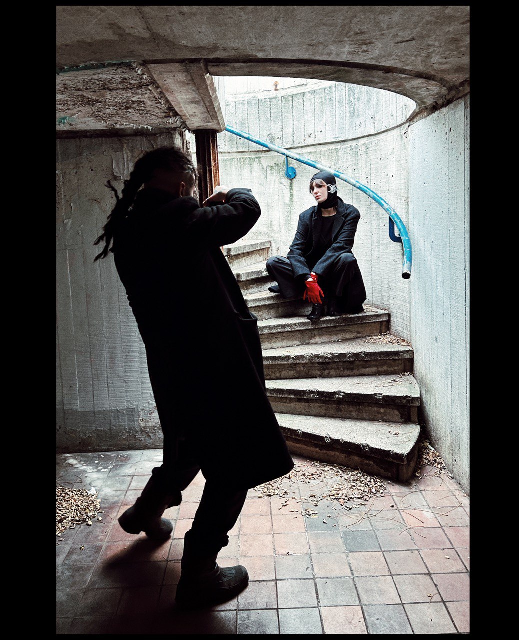 Concrete spiral staircase with photographer and seated figure