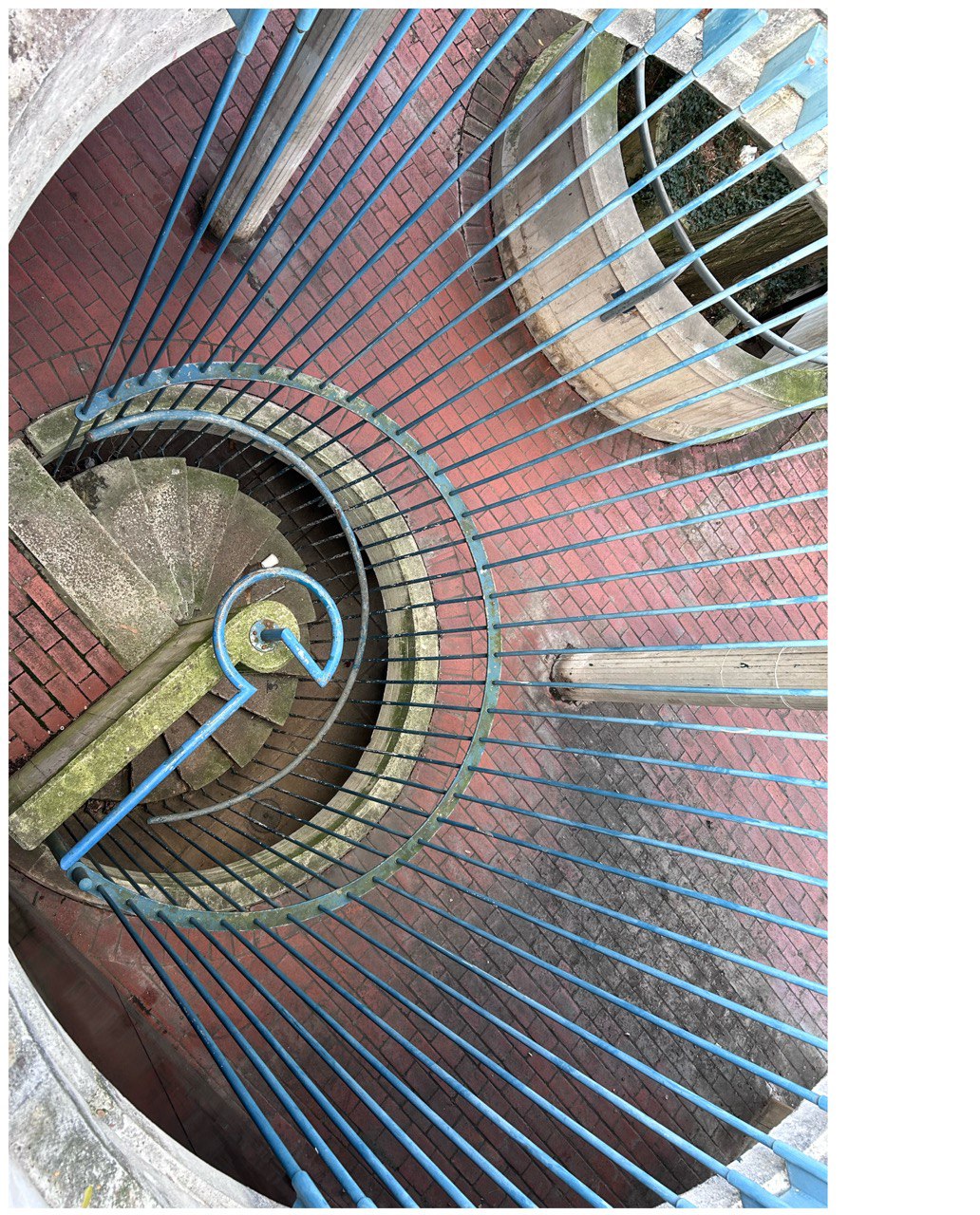 View down a circular staircase with blue metal bars